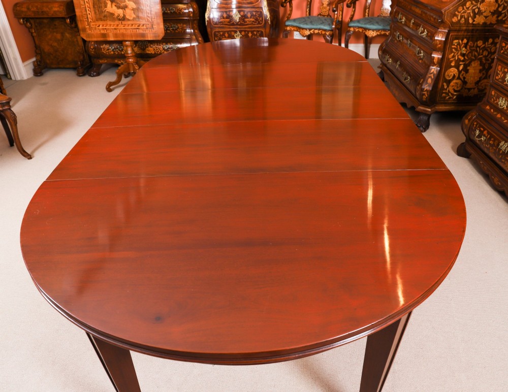 An antique Victorian oval extending dining table crafted from flame mahogany with tapered legs on brass castors. View IX