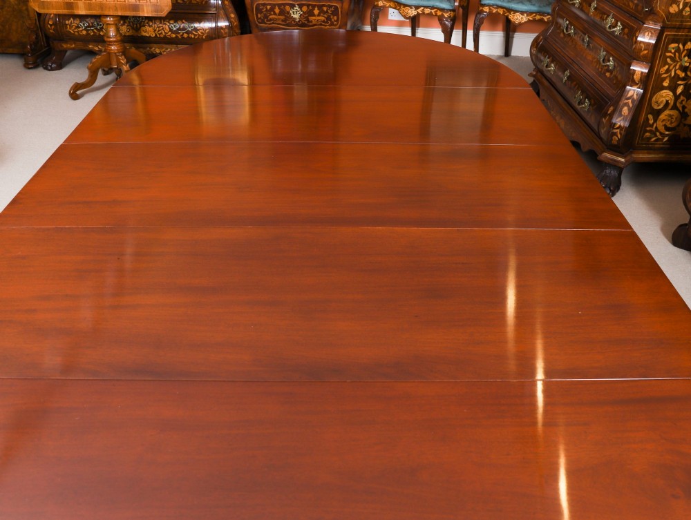 An antique Victorian oval extending dining table crafted from flame mahogany with tapered legs on brass castors. View X