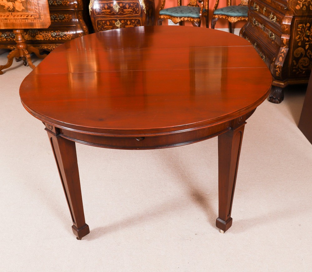 An antique Victorian oval extending dining table crafted from flame mahogany with tapered legs on brass castors. View XI