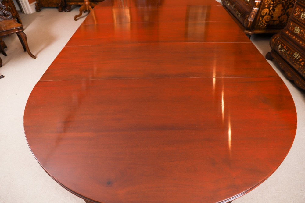 An antique Victorian oval extending dining table crafted from flame mahogany with tapered legs on brass castors. View XII