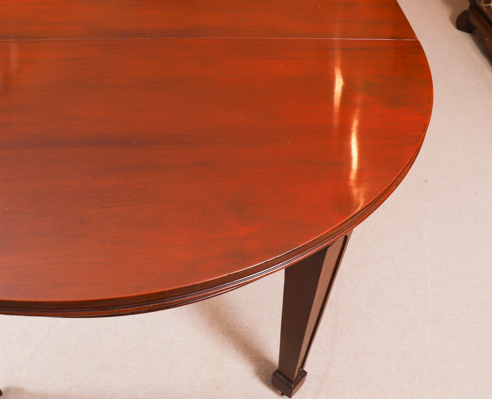 An antique Victorian oval extending dining table crafted from flame mahogany with tapered legs on brass castors. View XIV