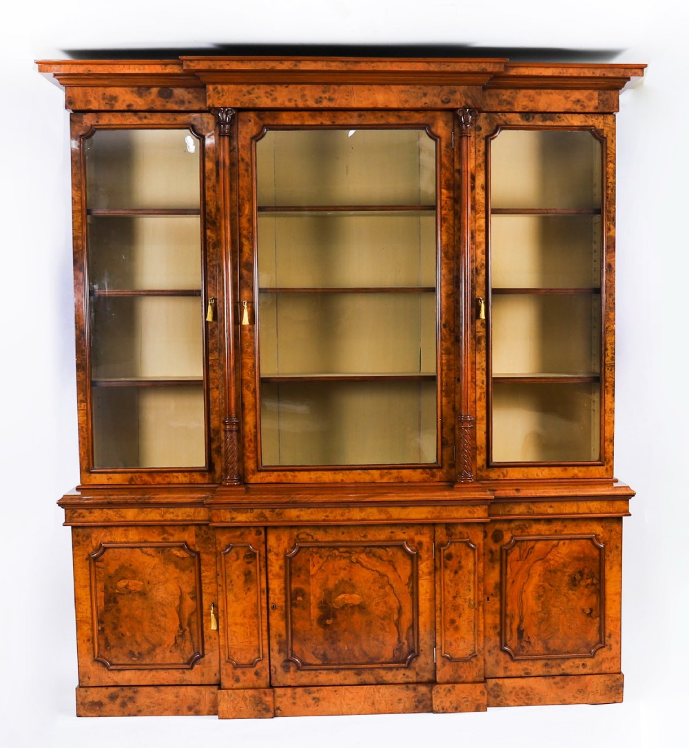 A mid-19th-century Victorian burr walnut breakfront bookcase featuring three upper glazed doors, turned pilasters, and three lower panelled cupboard doors. View II