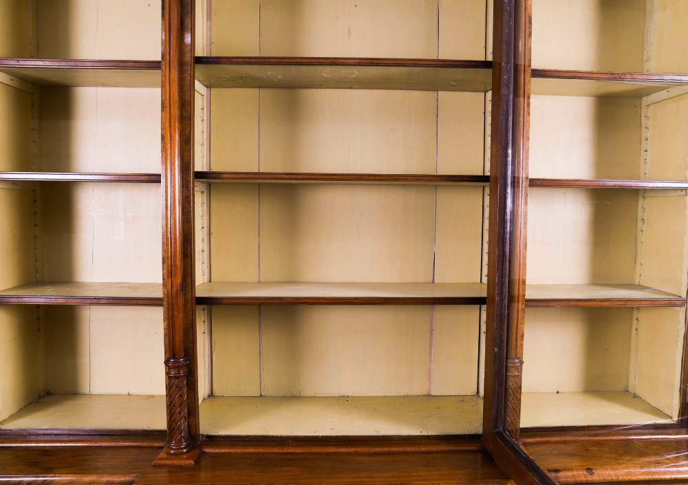 A mid-19th-century Victorian burr walnut breakfront bookcase featuring three upper glazed doors, turned pilasters, and three lower panelled cupboard doors. View X