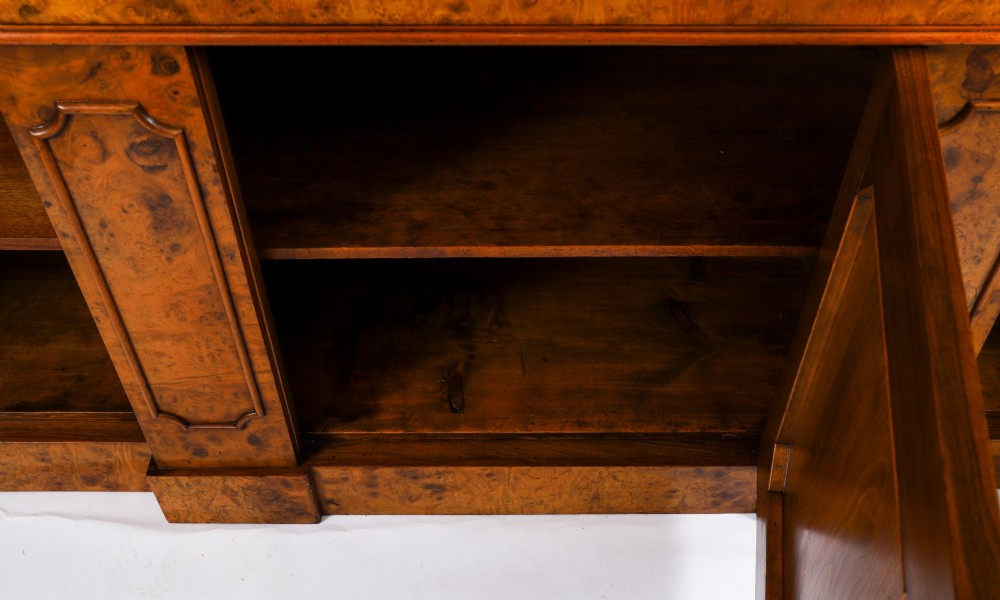 A mid-19th-century Victorian burr walnut breakfront bookcase featuring three upper glazed doors, turned pilasters, and three lower panelled cupboard doors. View XI