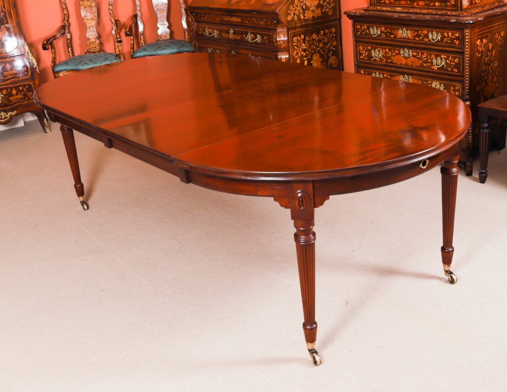 An antique Victorian flame mahogany extending dining table with fluted tapering legs set on brass castors.