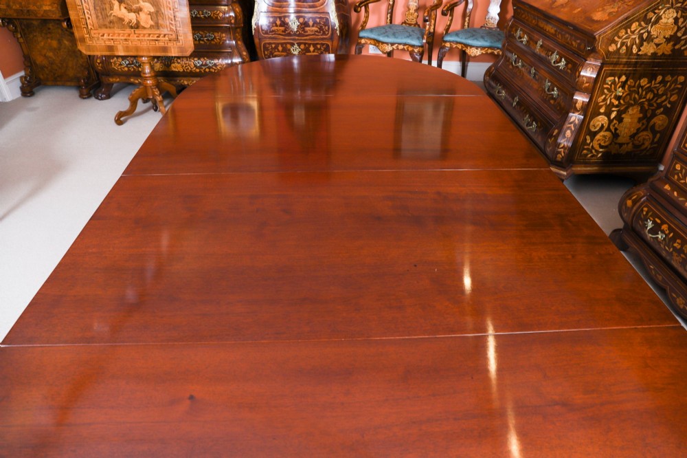 An antique Victorian flame mahogany extending dining table with fluted tapering legs set on brass castors. View VI