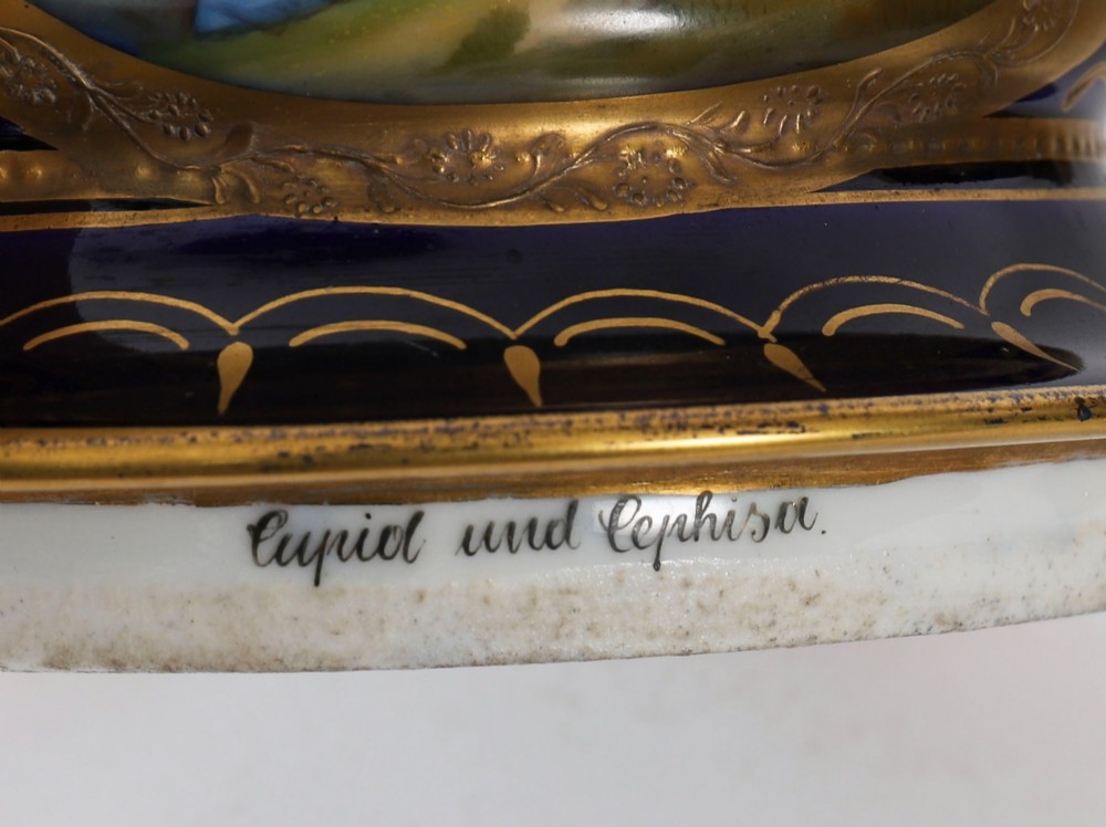 A pair of large 19th-century cobalt blue porcelain vases on matching square pedestals, featuring gilt scrollwork and hand-painted classical mythological scenes. View VII
