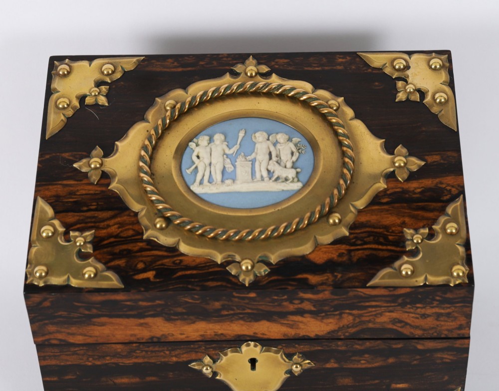 A three-piece Victorian coromandel wood desk set featuring gilt ormolu mounts, brass strapwork, and light blue oval jasperware plaques. View VI