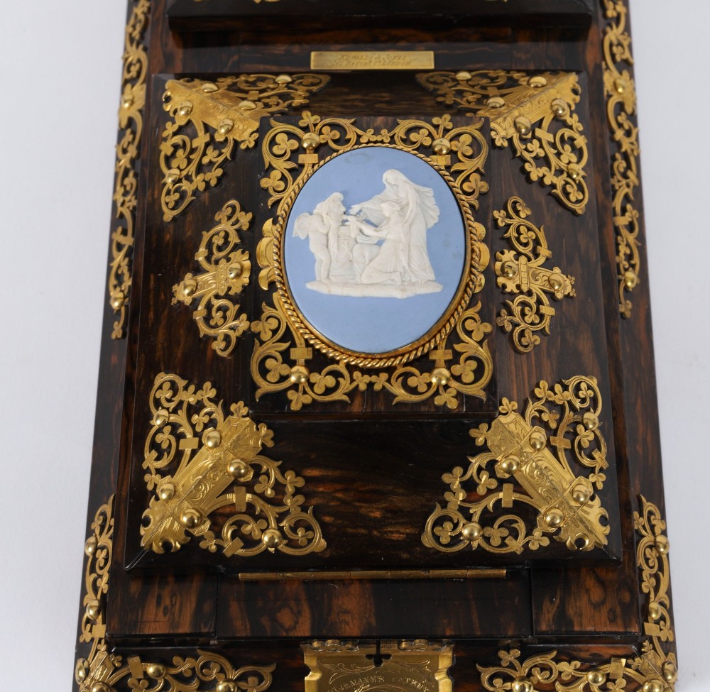 A three-piece Victorian coromandel wood desk set featuring gilt ormolu mounts, brass strapwork, and light blue oval jasperware plaques. View XII