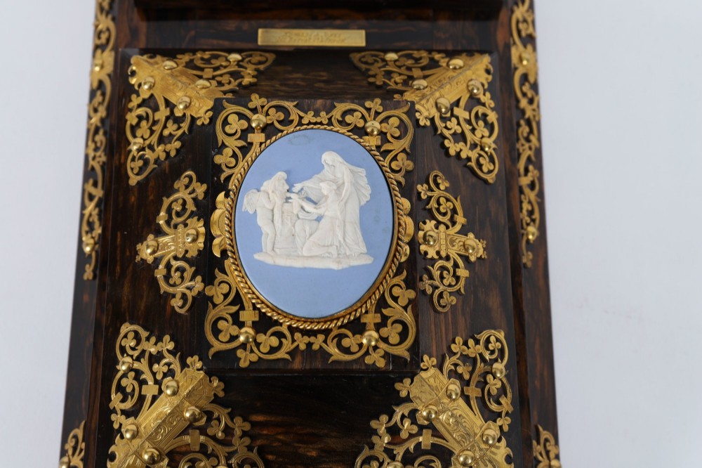 A three-piece Victorian coromandel wood desk set featuring gilt ormolu mounts, brass strapwork, and light blue oval jasperware plaques. View XIV