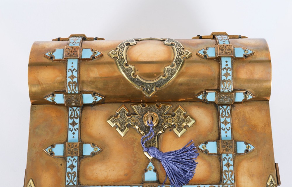 A Victorian gilt brass and turquoise champleve enamel writing slope featuring a domed upper compartment, a sloped front lid, and a key with a purple tassel in the lock. View VI