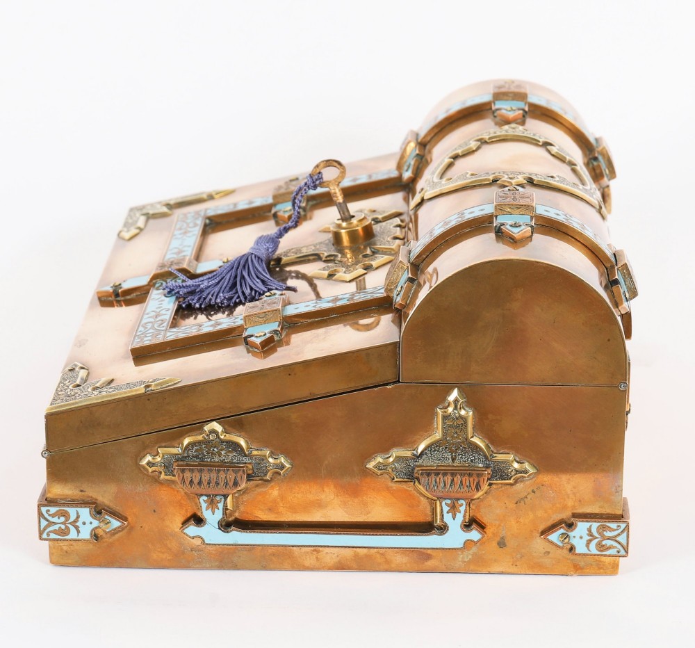 A Victorian gilt brass and turquoise champleve enamel writing slope featuring a domed upper compartment, a sloped front lid, and a key with a purple tassel in the lock. View XIII