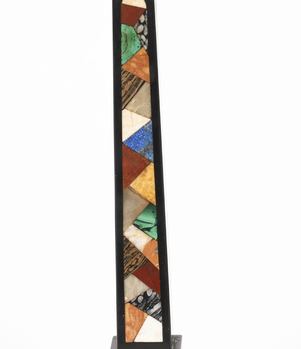 A pair of antique black marble obelisks featuring colourful geometric stone inlays along the shaft and floral inlaid detail on stepped square bases. View V