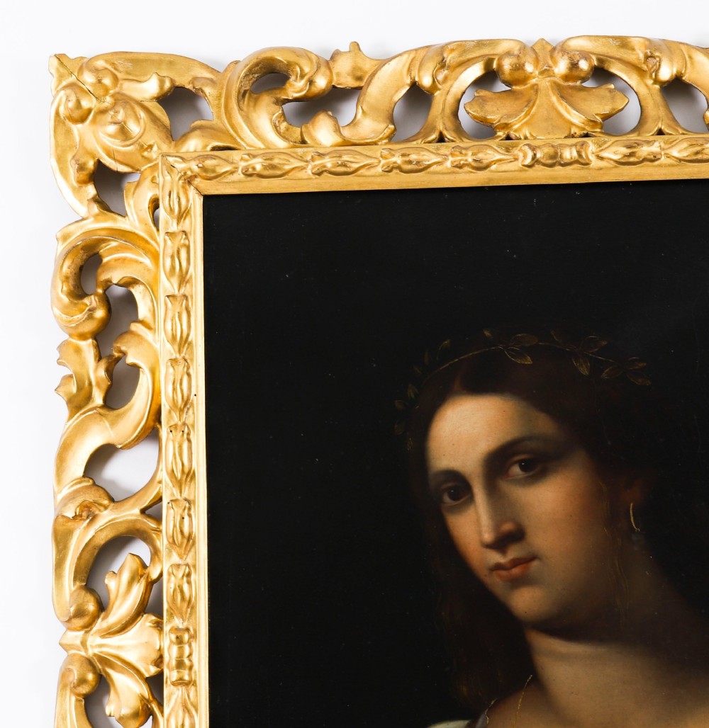 An early 19th-century portrait oil painting of a woman in classical attire set within a heavily carved gold giltwood frame. View V