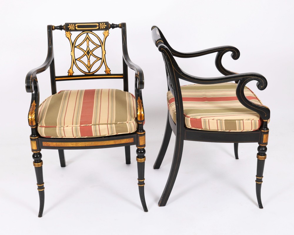 A set of ten black painted Regency Revival armchairs with parcel-gilt details, pierced splat backs, turned front legs, and striped fabric seat cushions. View II
