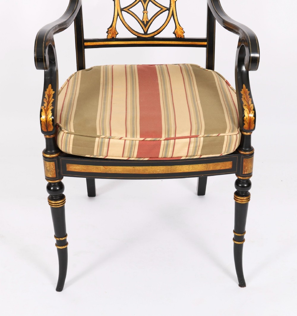 A set of ten black painted Regency Revival armchairs with parcel-gilt details, pierced splat backs, turned front legs, and striped fabric seat cushions. View VII