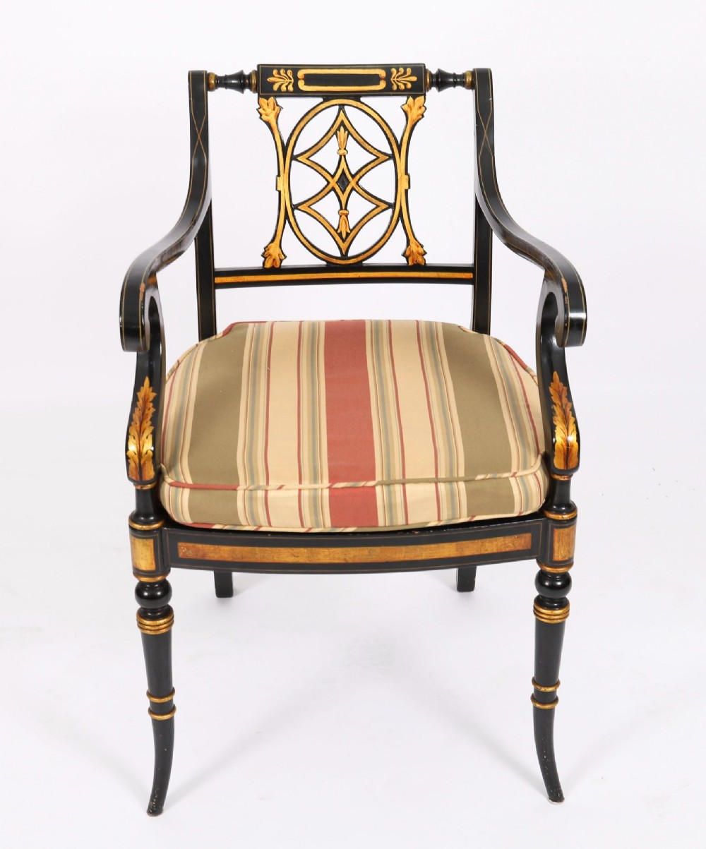 A set of ten black painted Regency Revival armchairs with parcel-gilt details, pierced splat backs, turned front legs, and striped fabric seat cushions. View XIV