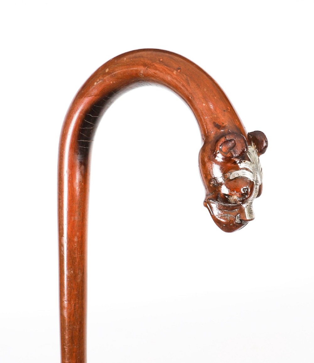 An antique dark wood walking stick featuring a curved crook handle carved into the detailed head of a boxer dog. View VI