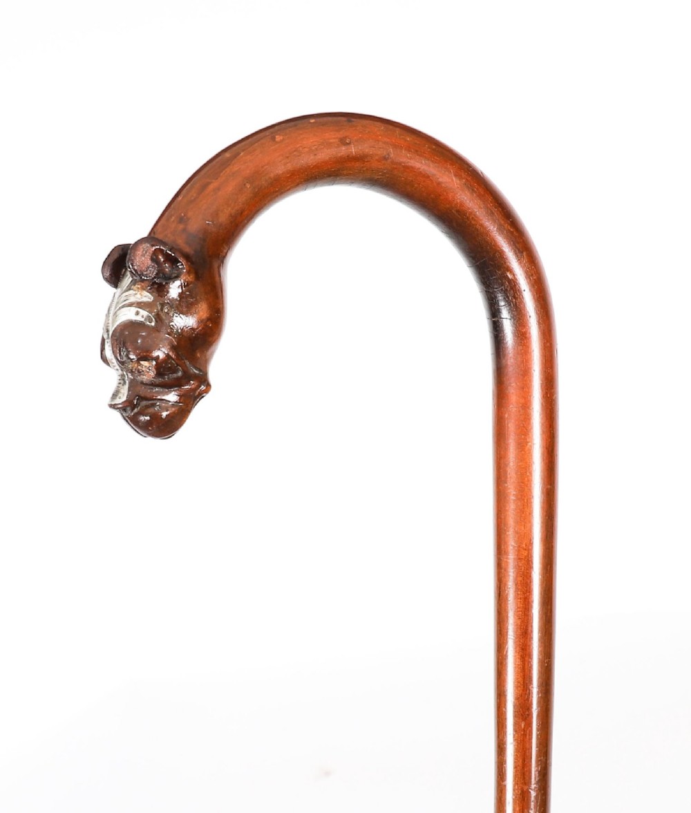 An antique dark wood walking stick featuring a curved crook handle carved into the detailed head of a boxer dog. View VII