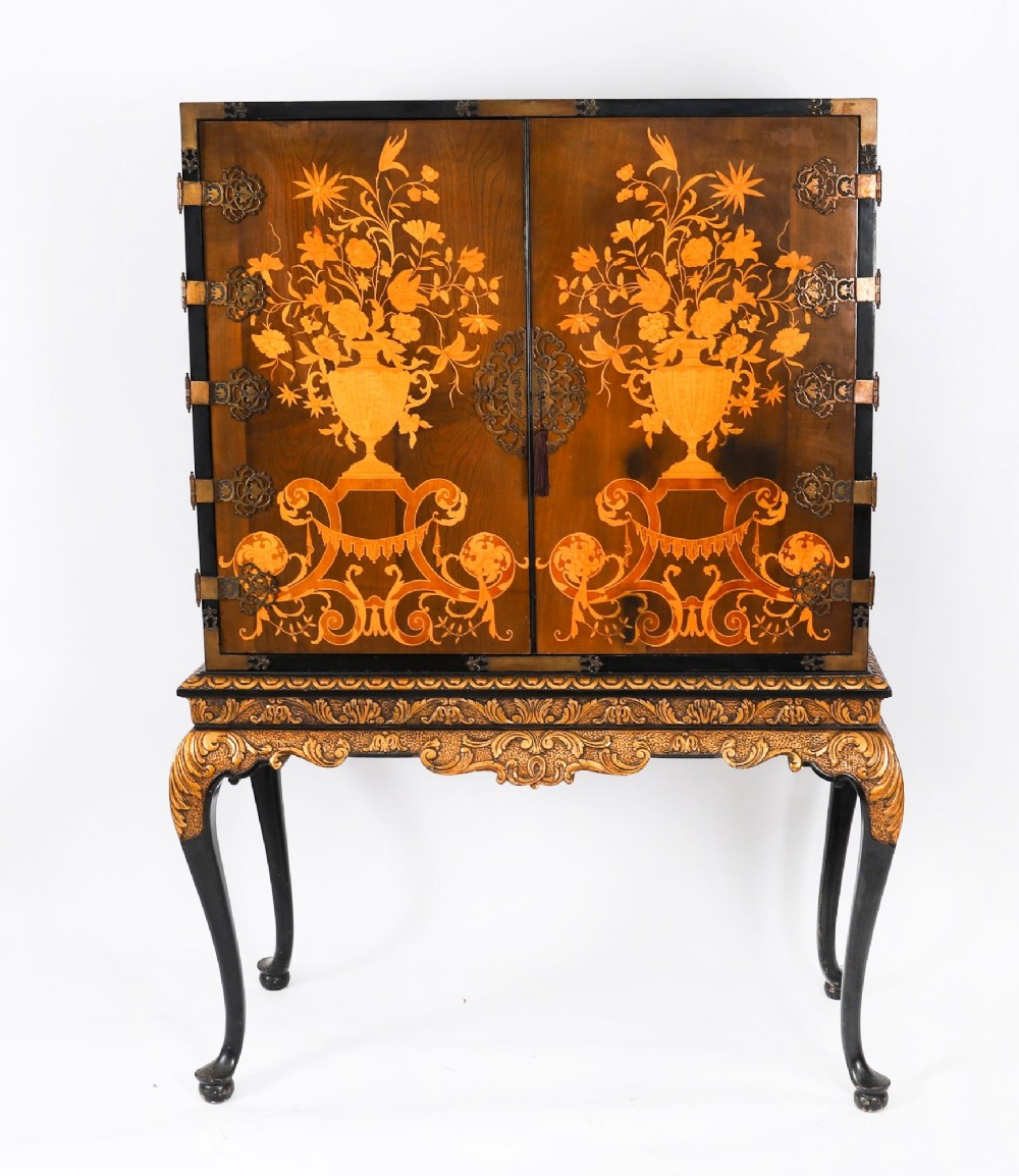 A black lacquered and inlaid wooden cocktail cabinet featuring ornate floral marquetry and decorative brass straps, resting on a carved gilded stand with cabriole legs. View III