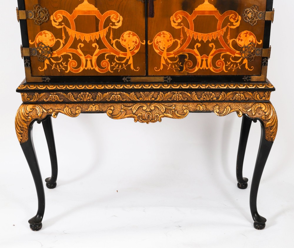 A black lacquered and inlaid wooden cocktail cabinet featuring ornate floral marquetry and decorative brass straps, resting on a carved gilded stand with cabriole legs. View VIII