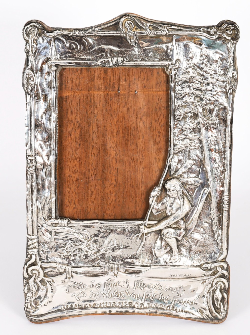 An Edwardian sterling silver picture frame featuring an embossed relief scene of Hiawatha with a wooden backing.