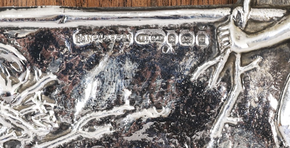 An Edwardian sterling silver picture frame featuring an embossed relief scene of Hiawatha with a wooden backing. View VI