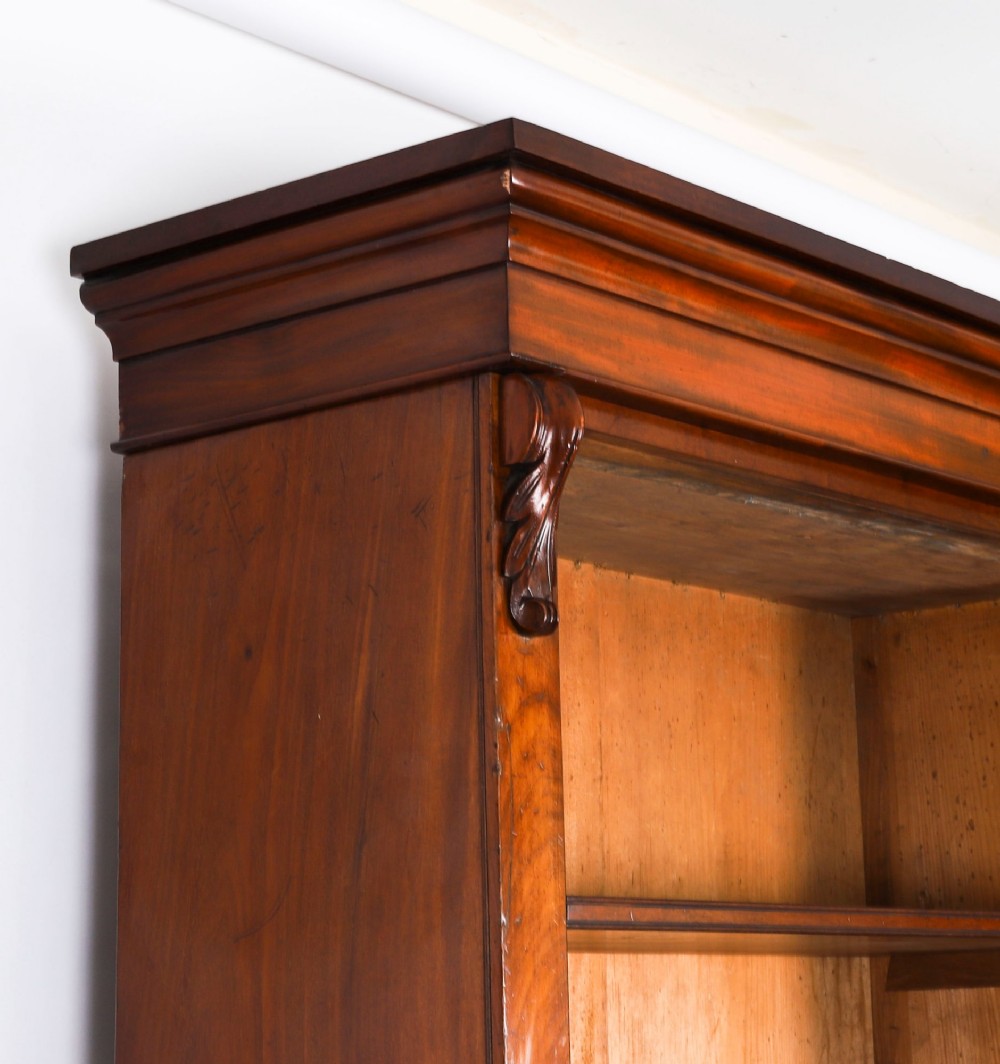 A tall Victorian mahogany open bookcase featuring six tiers of adjustable shelves, flanked by decorative carved corbels under a projected cornice. View VII
