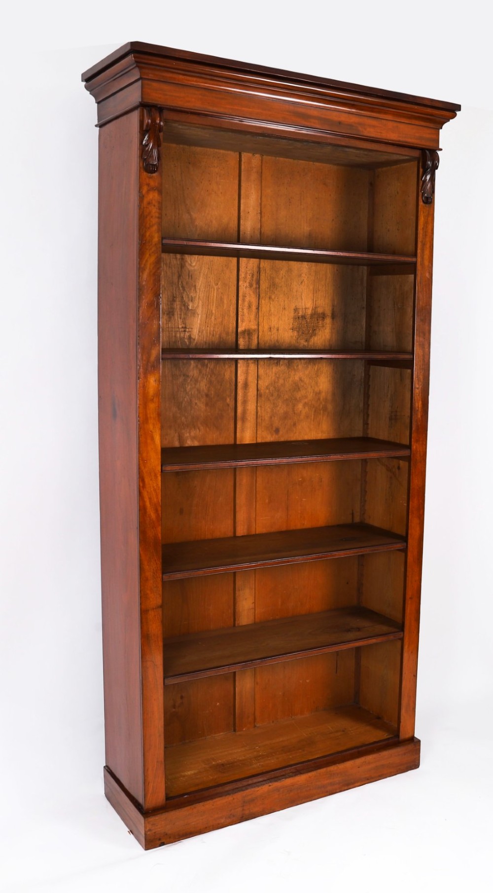 A tall Victorian mahogany open bookcase featuring six tiers of adjustable shelves, flanked by decorative carved corbels under a projected cornice. View X
