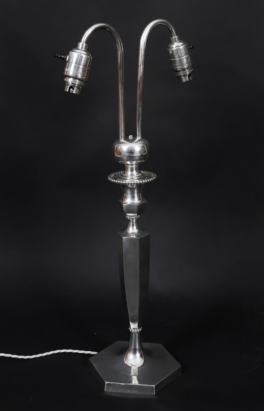 An Art Deco silver-plated twin-arm table lamp with a faceted stem and hexagonal base. View II