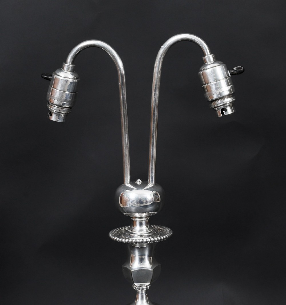 An Art Deco silver-plated twin-arm table lamp with a faceted stem and hexagonal base. View VI