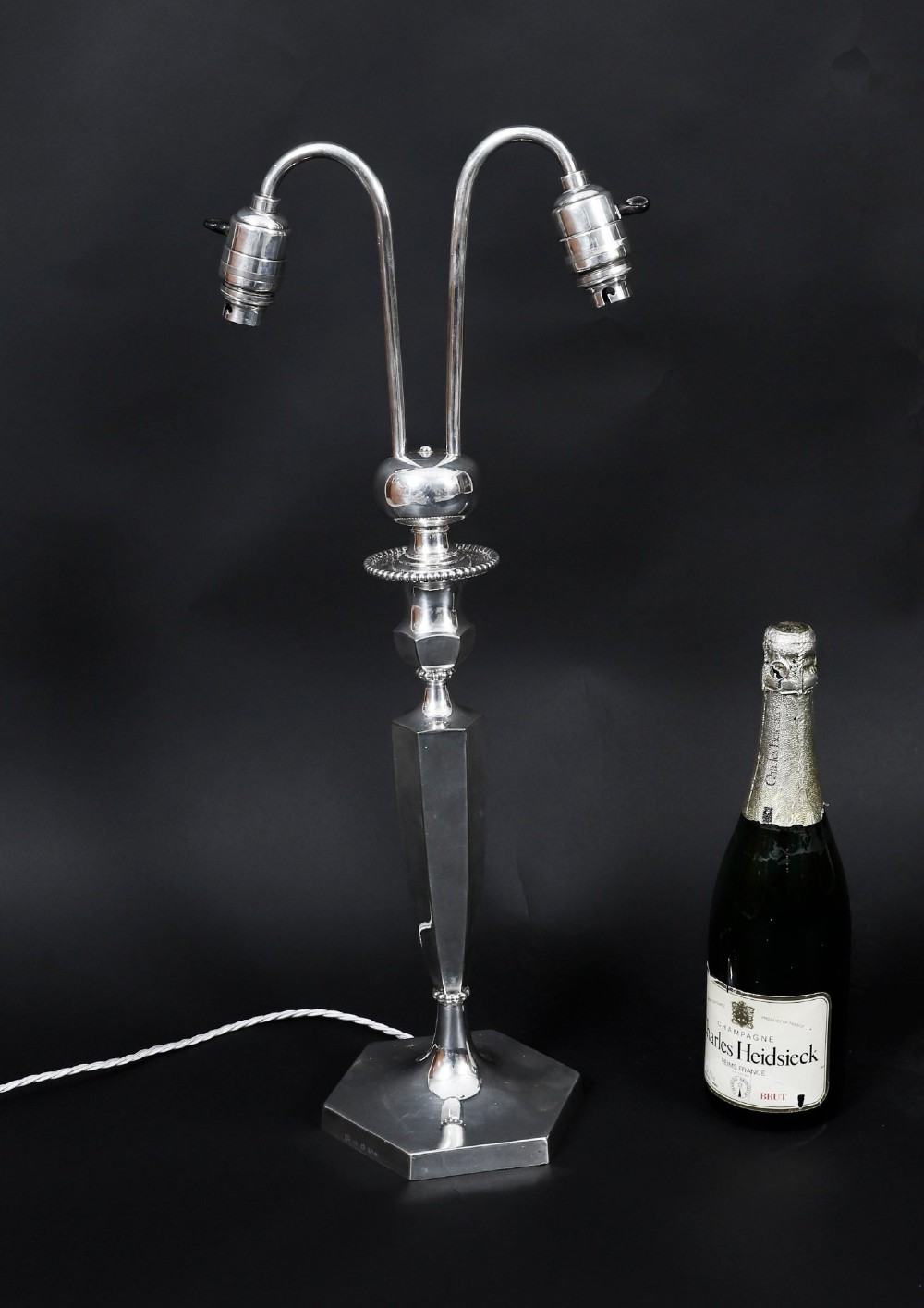 An Art Deco silver-plated twin-arm table lamp with a faceted stem and hexagonal base. View IX