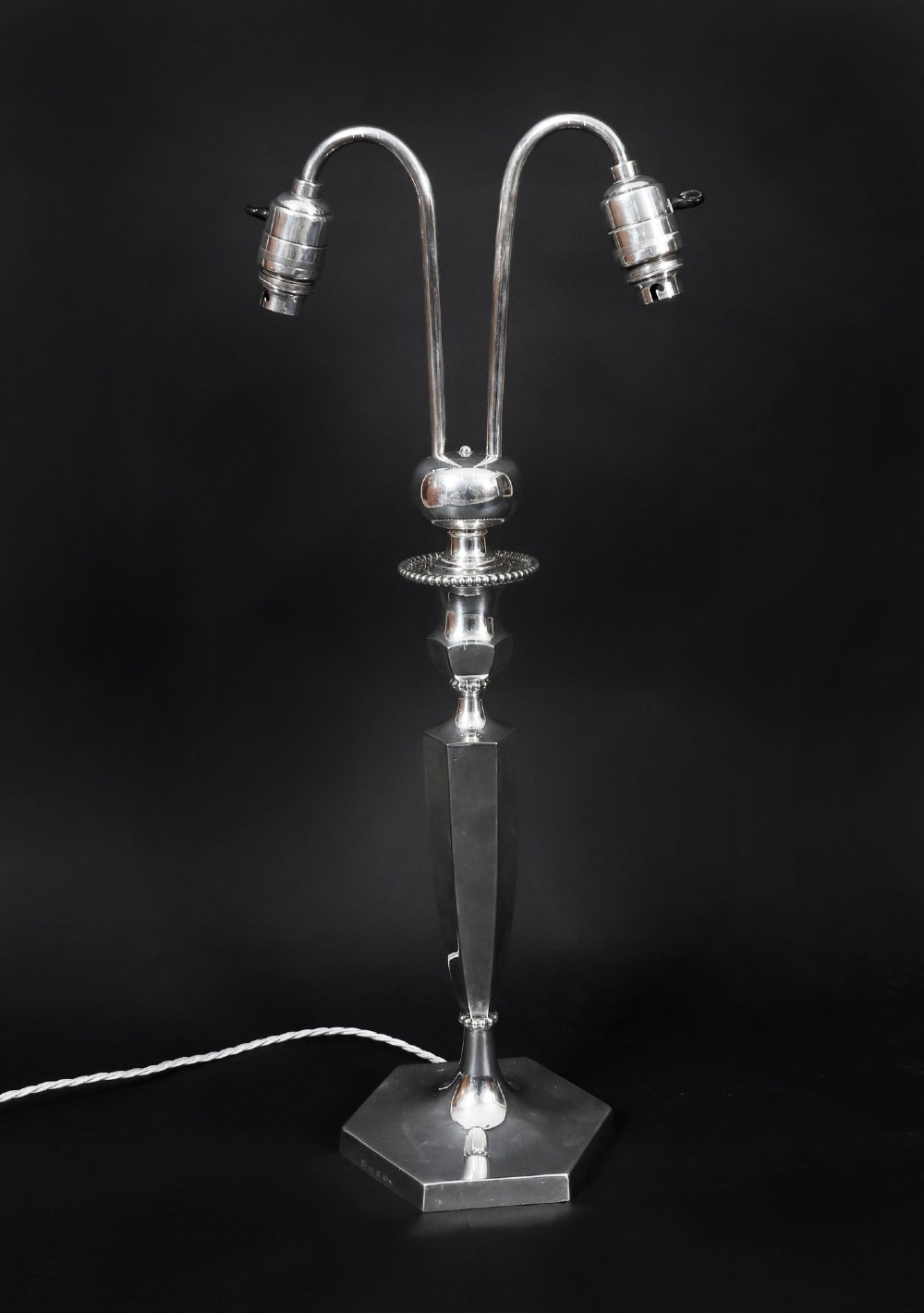 An Art Deco silver-plated twin-arm table lamp with a faceted stem and hexagonal base. View X