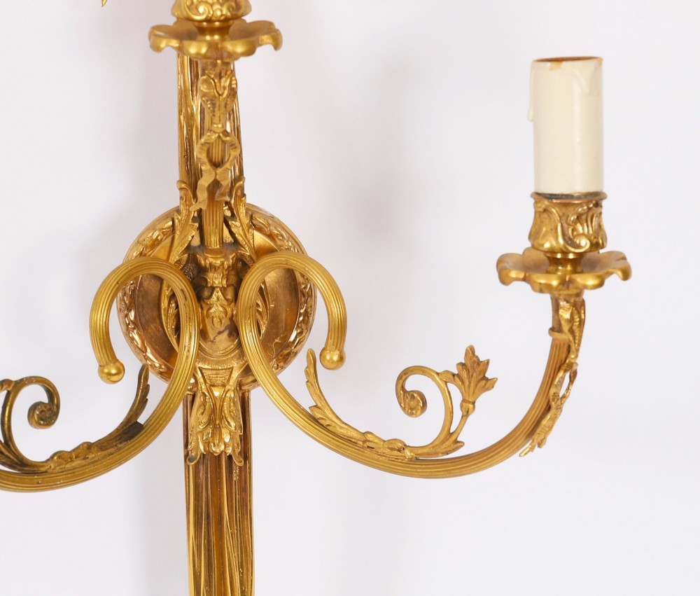 A pair of 19th-century French gilt bronze three-branch wall sconces styled with ribbon bow tops and tassel finials. View VIII
