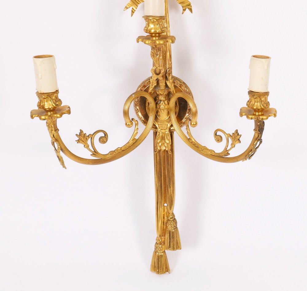 Set of four gilt bronze three-branch wall lights featuring ribbon bow cresting and hanging tassel drops. View VIII