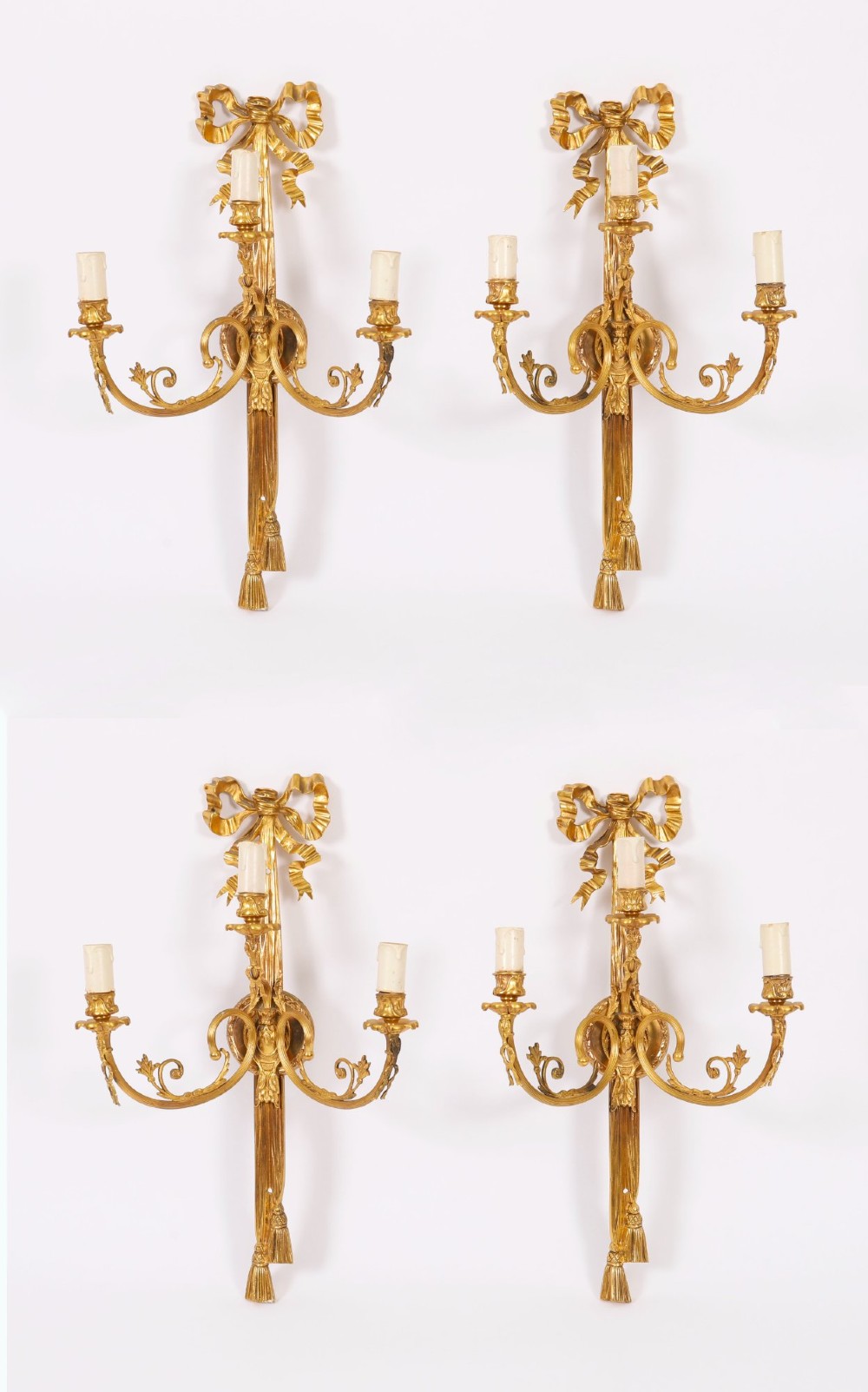 Set of four gilt bronze three-branch wall lights featuring ribbon bow cresting and hanging tassel drops. View X