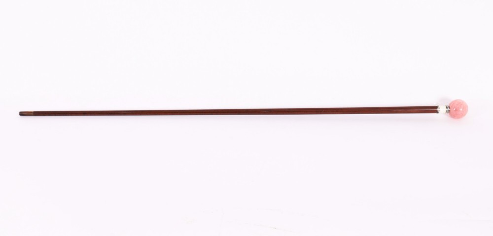 An antique walking stick featuring a spherical pink quartz pommel set above a white enamel collar with silver beaded borders and a dark wood shaft. View II
