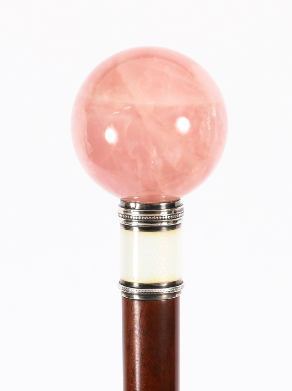 An antique walking stick featuring a spherical pink quartz pommel set above a white enamel collar with silver beaded borders and a dark wood shaft. View XI