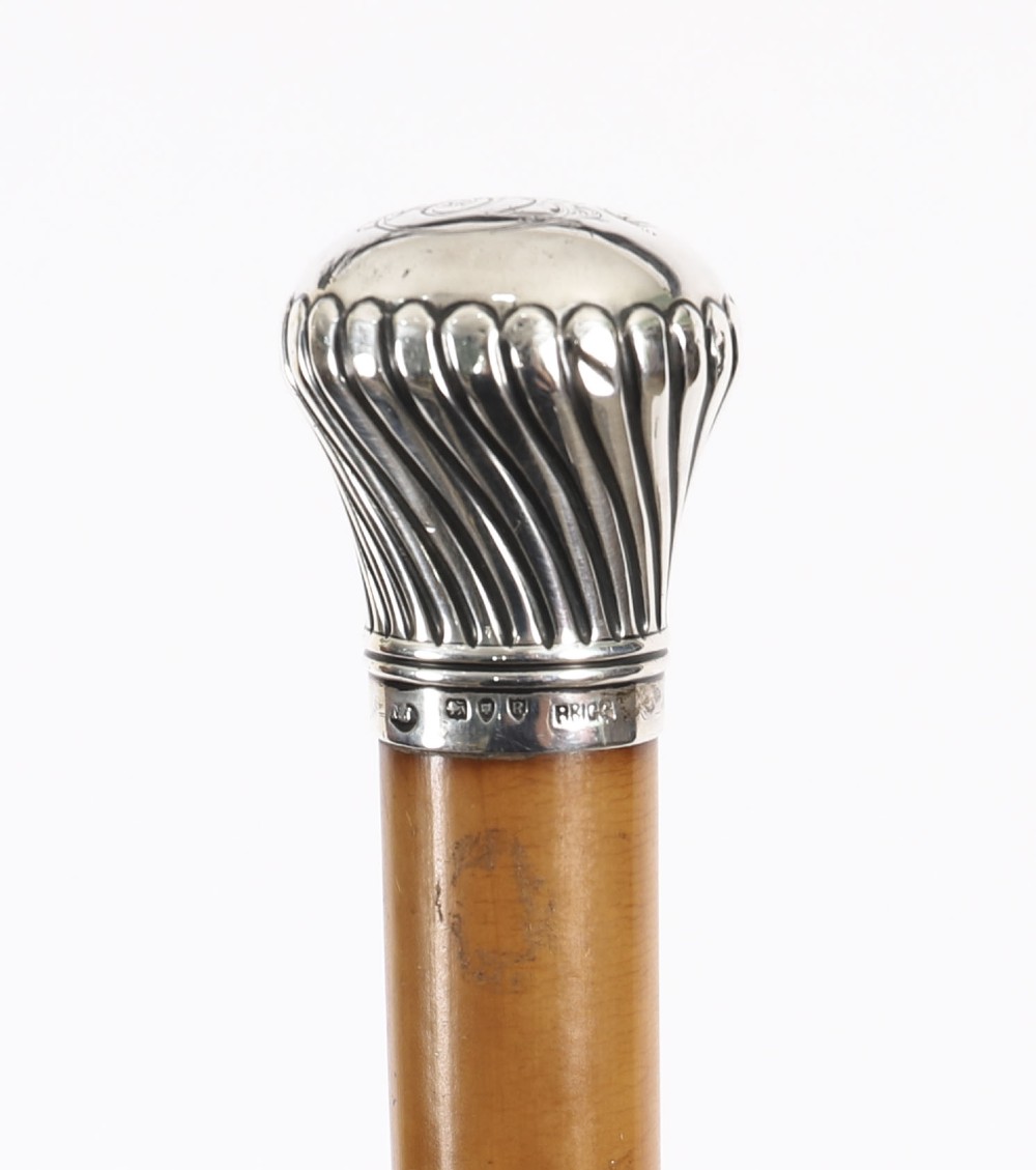 Victorian walking cane featuring an engraved sterling silver pommel with spiralled fluting mounted on a light wood shaft. View III