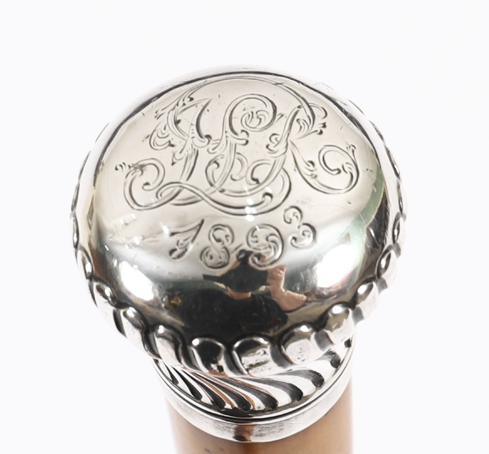 Victorian walking cane featuring an engraved sterling silver pommel with spiralled fluting mounted on a light wood shaft. View IV