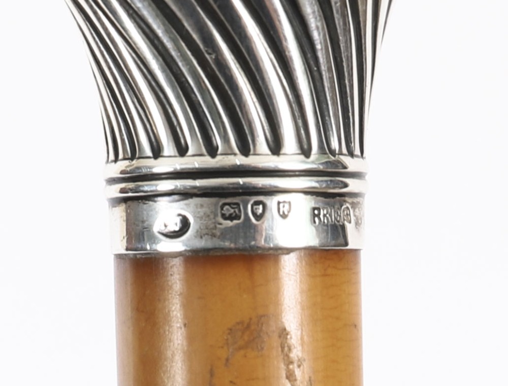 Victorian walking cane featuring an engraved sterling silver pommel with spiralled fluting mounted on a light wood shaft. View XIII