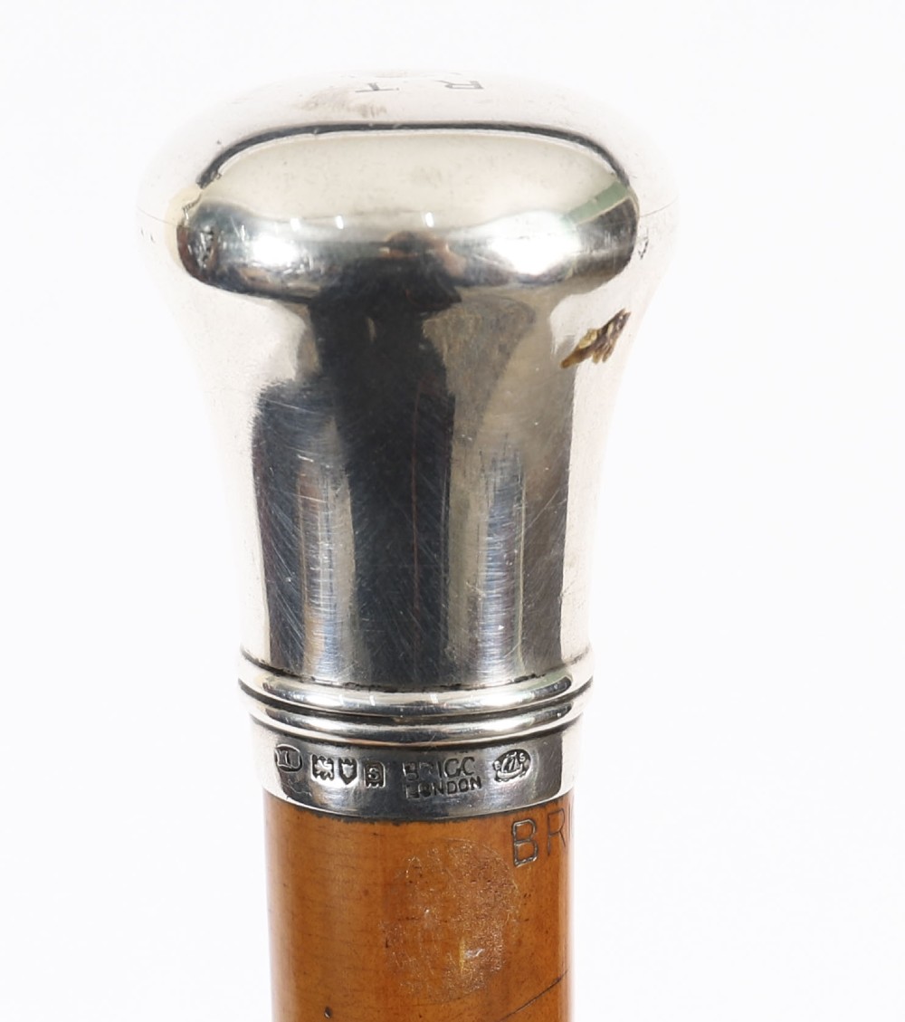 An Edwardian walking stick featuring a smooth domed sterling silver pommel and a polished wooden shaft. View VI