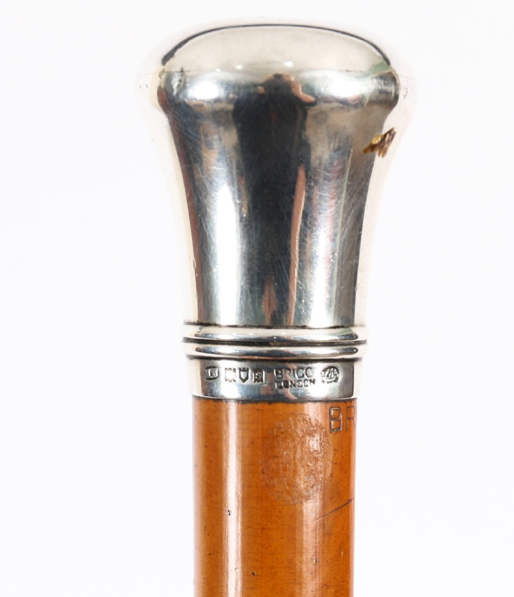 An Edwardian walking stick featuring a smooth domed sterling silver pommel and a polished wooden shaft. View VII