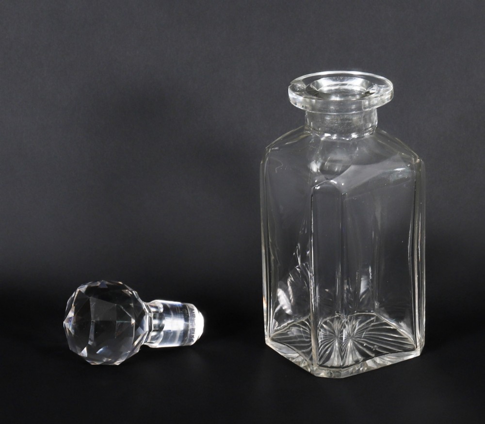 An open and closed 19th-century Victorian burr walnut tantalus box containing three cut crystal decanters, brass-mounted liqueur glasses, and a deep blue velvet lining. View XI