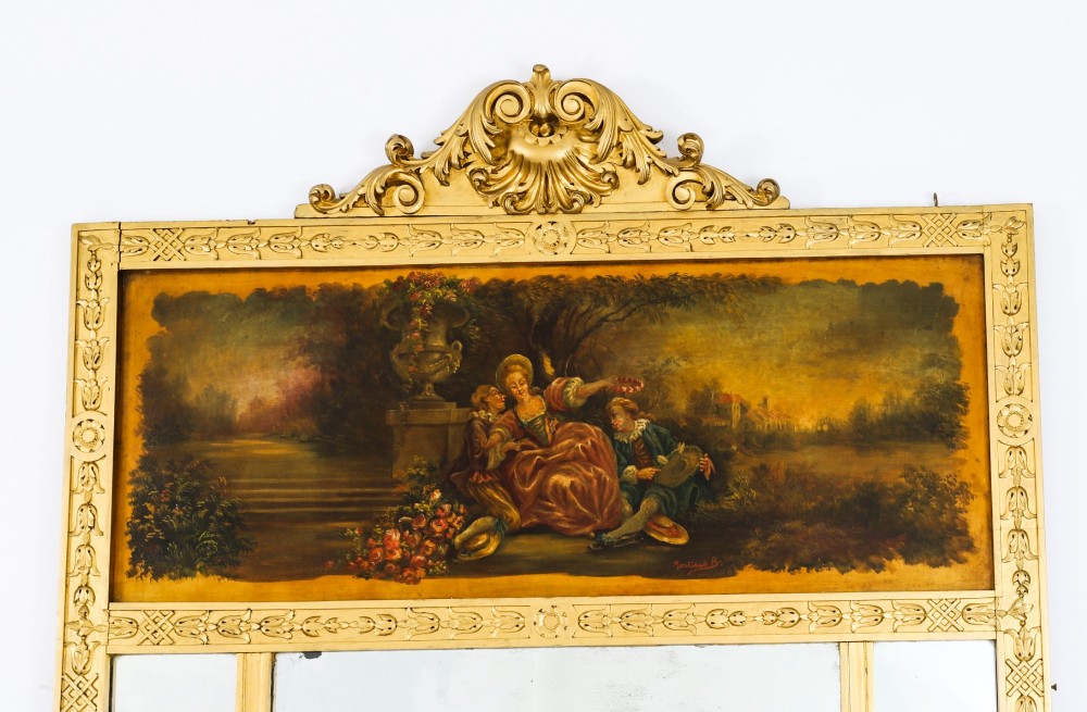 An antique French giltwood trumeau mirror with a painted pastoral scene top panel, carved shell cresting, and three glass mirror sections. View II