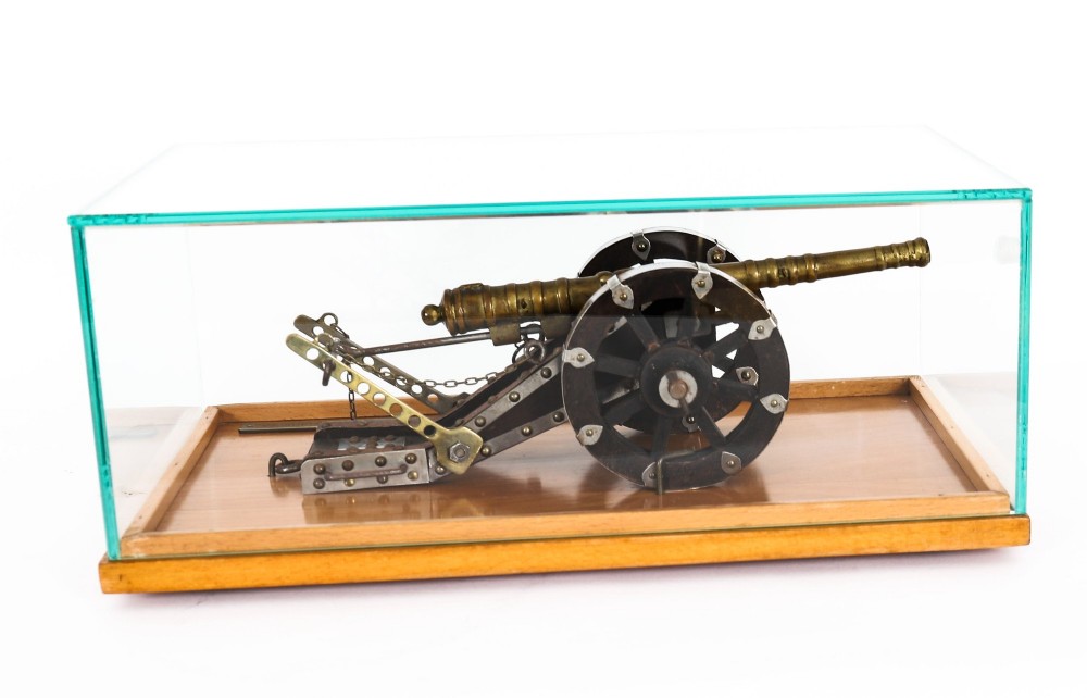 A 19th-century bronze model cannon mounted on a dark wooden carriage and enclosed within a clear glass display case. View XIV