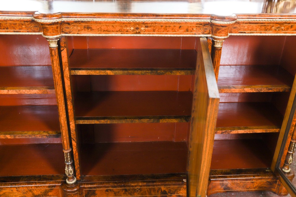 A nineteenth-century Victorian burr walnut credenza featuring an arched mirror back, glazed side doors, and a central cupboard inlaid with a porcelain plaque. View XV