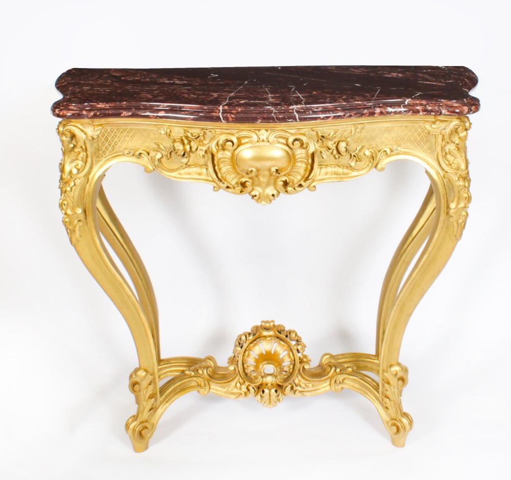 A 19th-century French Louis XV Revival giltwood console table featuring carved cabriole legs, a central shell cartouche stretcher, and a reddish-brown marble top. View III