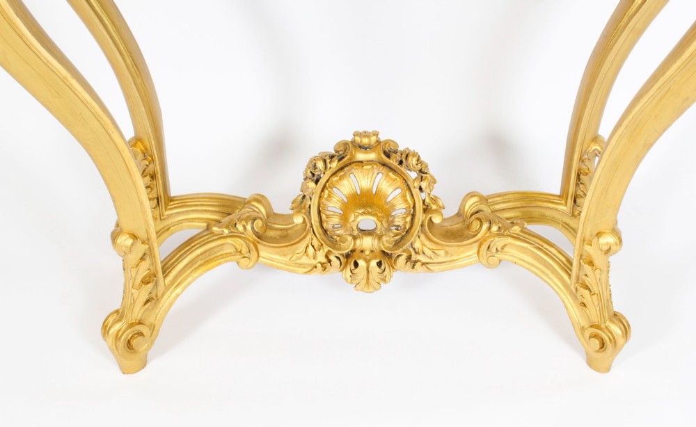 A 19th-century French Louis XV Revival giltwood console table featuring carved cabriole legs, a central shell cartouche stretcher, and a reddish-brown marble top. View XV