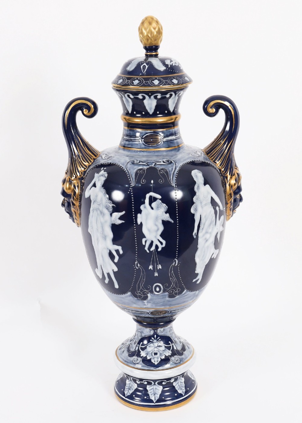 A pair of cobalt blue and white porcelain lidded vases featuring classical figures, scrolling handles, and gilded finials. View II